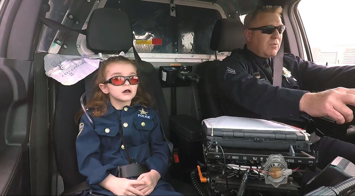 FILE - In this image from an April 2017 video provided by the Denver Police Department, Olivia Gant, who was 6 years old at the time, rides with Capt. Tim Scudder on a call in Denver. Olivia's mother, Kelly Turner, will be sentenced Wednesday, Feb. 9, 2022, after authorities say she duped doctors about her daughter’s health, leading to unnecessary surgeries and medications. Turner pled guilty in January to negligent child abuse, charitable fraud and theft between $100,000 and $1 million. (Denver Police Department via The Denver Post via AP)