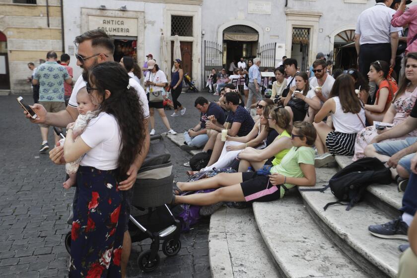 Tourists enjoy snacks and drinks as they sit in front of the Pantheon, in Rome, Friday, June 7, 2019. Tired of ad hoc bans on ill behavior by tourists, Rome has converted its temporary crackdowns into one big law. The city announced Friday that the city council had a day earlier approved the all-encompassing law. Most bans, like frolicking in monumental fountains or eating lunch on monuments, had been in effect for some time, but needed to be periodically renewed. (AP Photo/Gregorio Borgia)