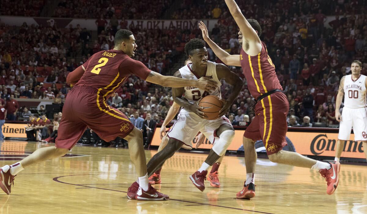 Oklahoma's Buddy Hield drives between Iowa State's Abdel Nader (2) and Georges Niang (31) during the second half on Saturday.