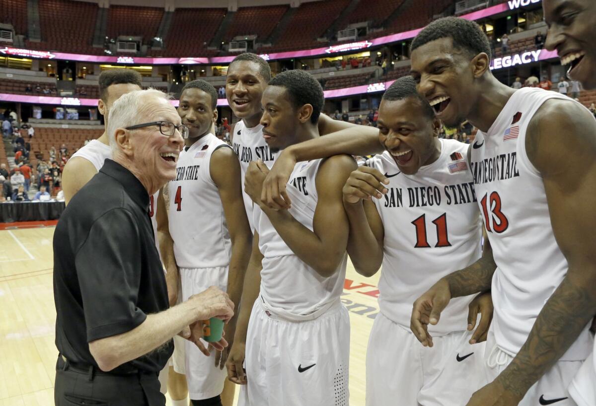 San Diego State head coach Steve Fisher and his players celebrate their win over Marquette in the championship game of the Wooden Legacy tournament in Anaheim, Calif.
