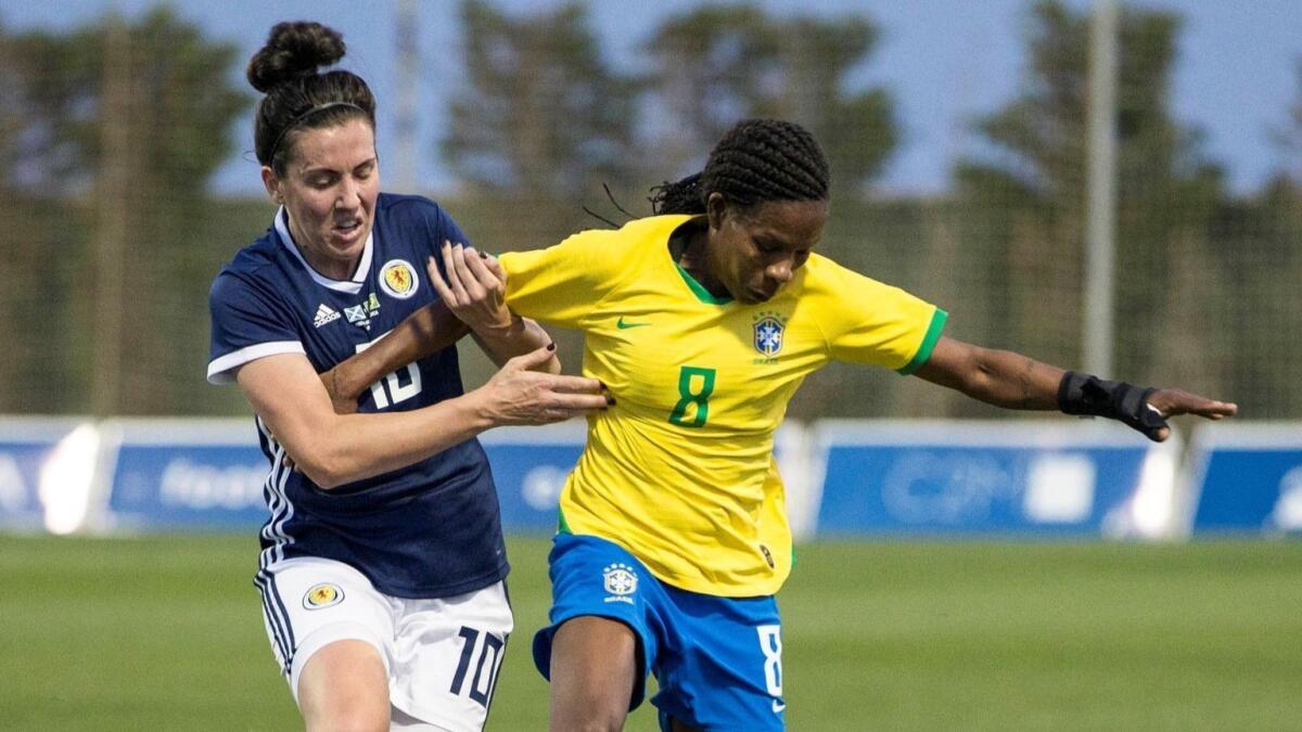 Brazil's Formiga, right, controls the ball ahead of Scotland's Leanne Crichton during an international friendly match in April. Formiga is the first player in soccer history to play in seven world championship tournaments.