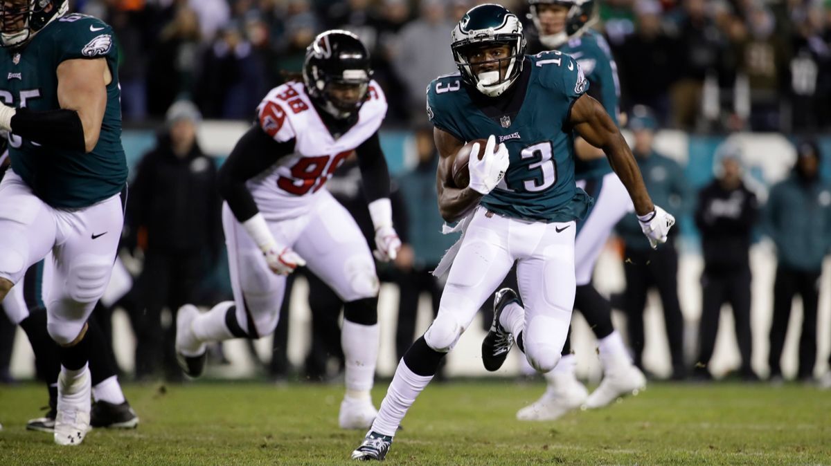 Philadelphia Eagles' Nelson Agholor (13) runs from Atlanta Falcons defenders during a NFC divisional round game on Jan. 13.