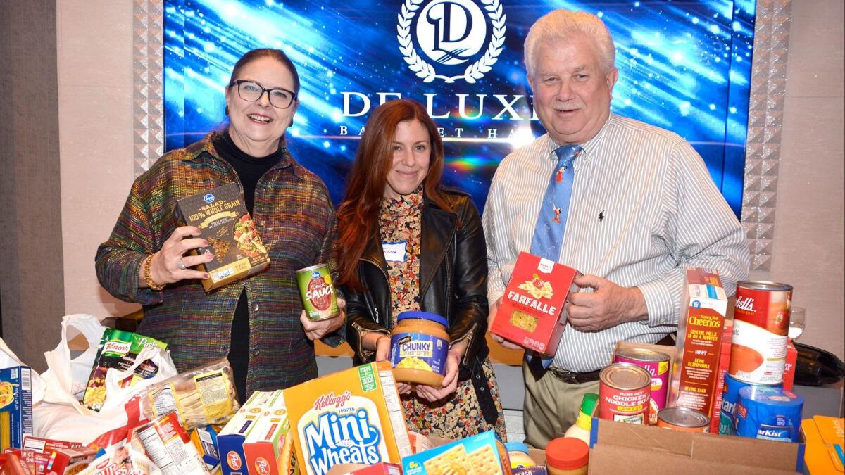 Joan Patricia "J.P." O'Connor-Thompson, left, and her husband, Cotton Thompson, flanked volunteer Jessica Prusakowski as provisions were accepted for the Los Angeles Regional Food Bank.