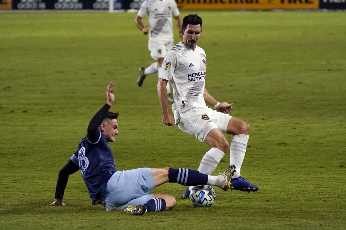 Vancouver Whitecaps's Jake Nerwinski, left, makes a slide tackle 