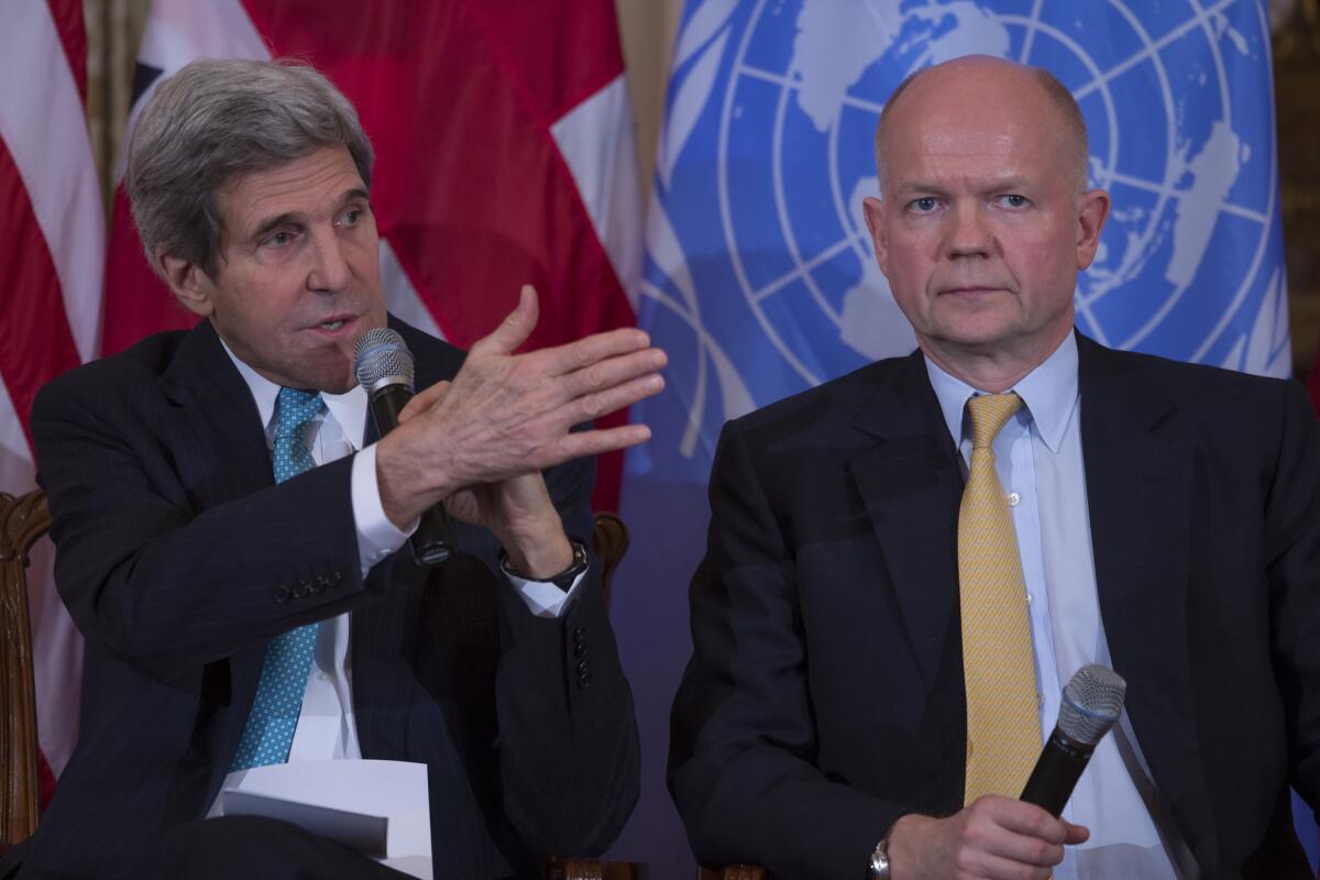 British Foreign Secretary William Hague listens at right as U.S. Secretary of State John F. Kerry speaks.