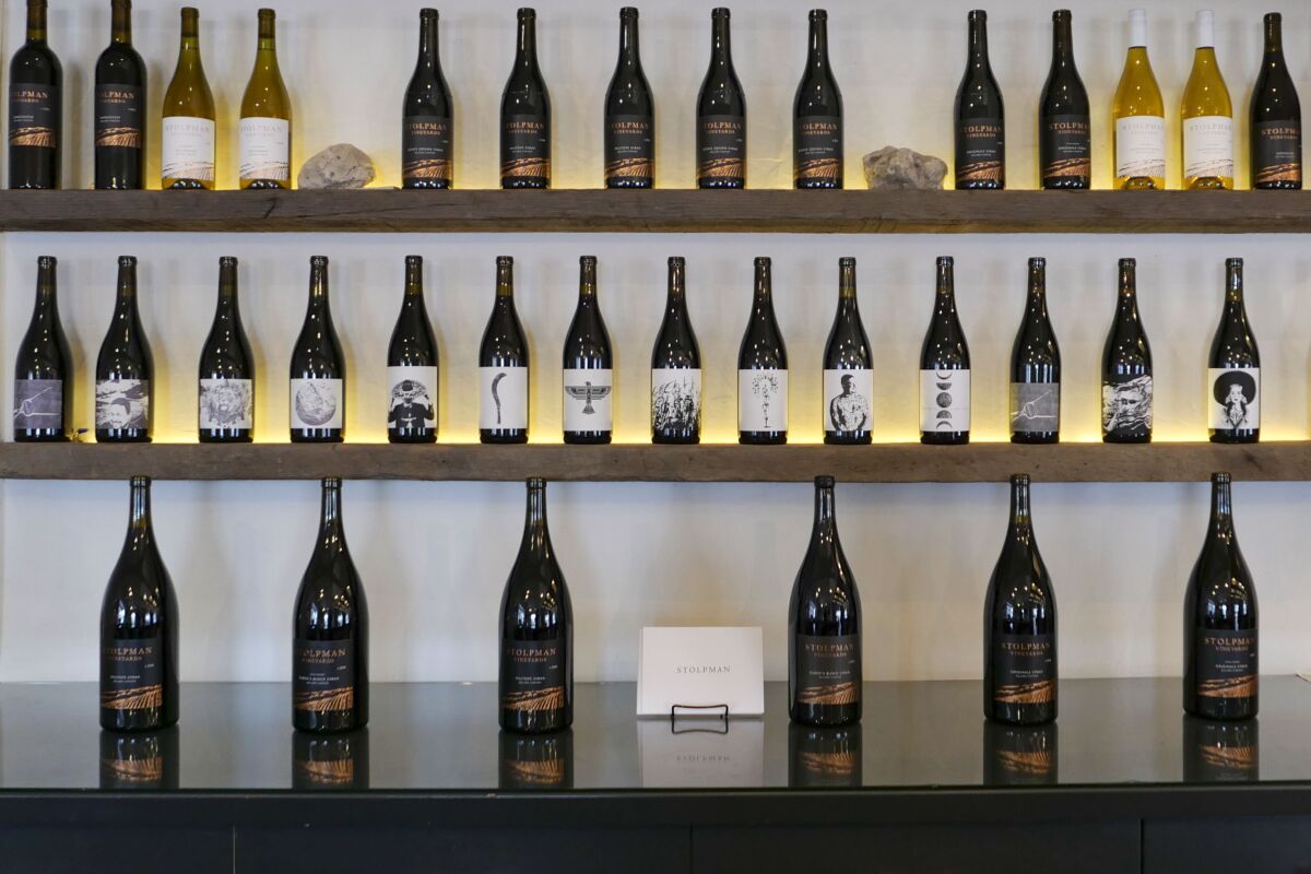 Three rows of wine bottles on shelves