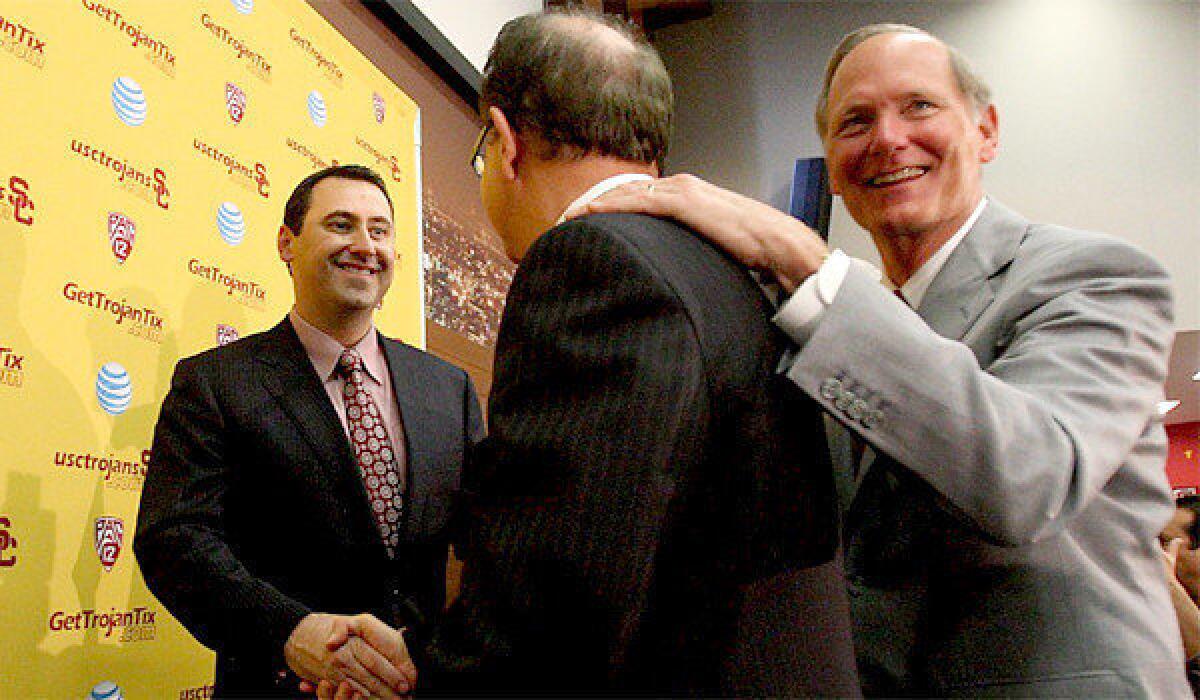 Newly introduced USC football Coach Steve Sarkisian, left, shakes hands with USC President C.L. Max Nikias and Athletic Director Pat Haden following a news conference Tuesday.
