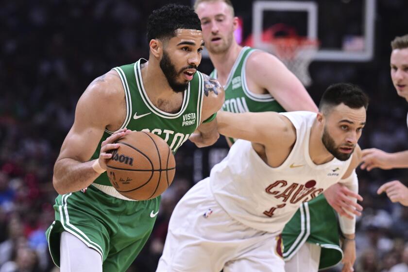 El alero de los Celtics de Boston Jayston Tatum (0) se dirige hacia el aro ante el base de los Cavaliers de Cleveland Max Strus (1) durante la primera mitad del Juego 4 de la serie de segunda ronda en los playoffs del baloncesto de la NBA, el lunes 13 de mayo de 2024, en Cleveland. (AP Foto/David Dermer)
