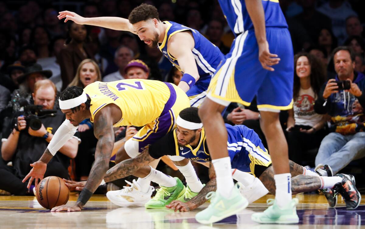 Lakers forward Jarred Vanderbilt, left, and Warriors guard Gary Payton II scramble for the loose ball.