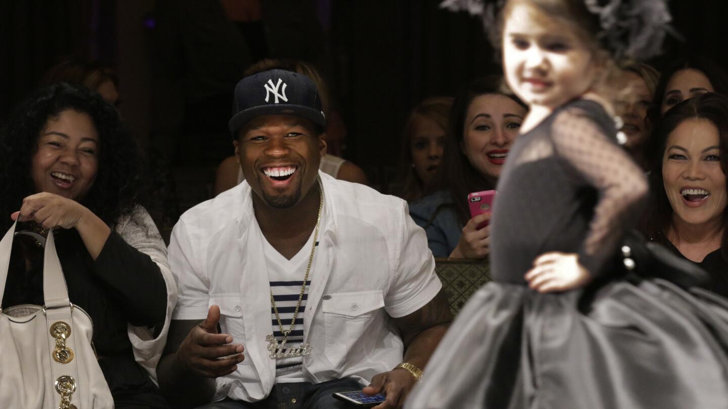 Rapper and business mogul 50 Cent beams at the Isabella Couture runway show for kids.