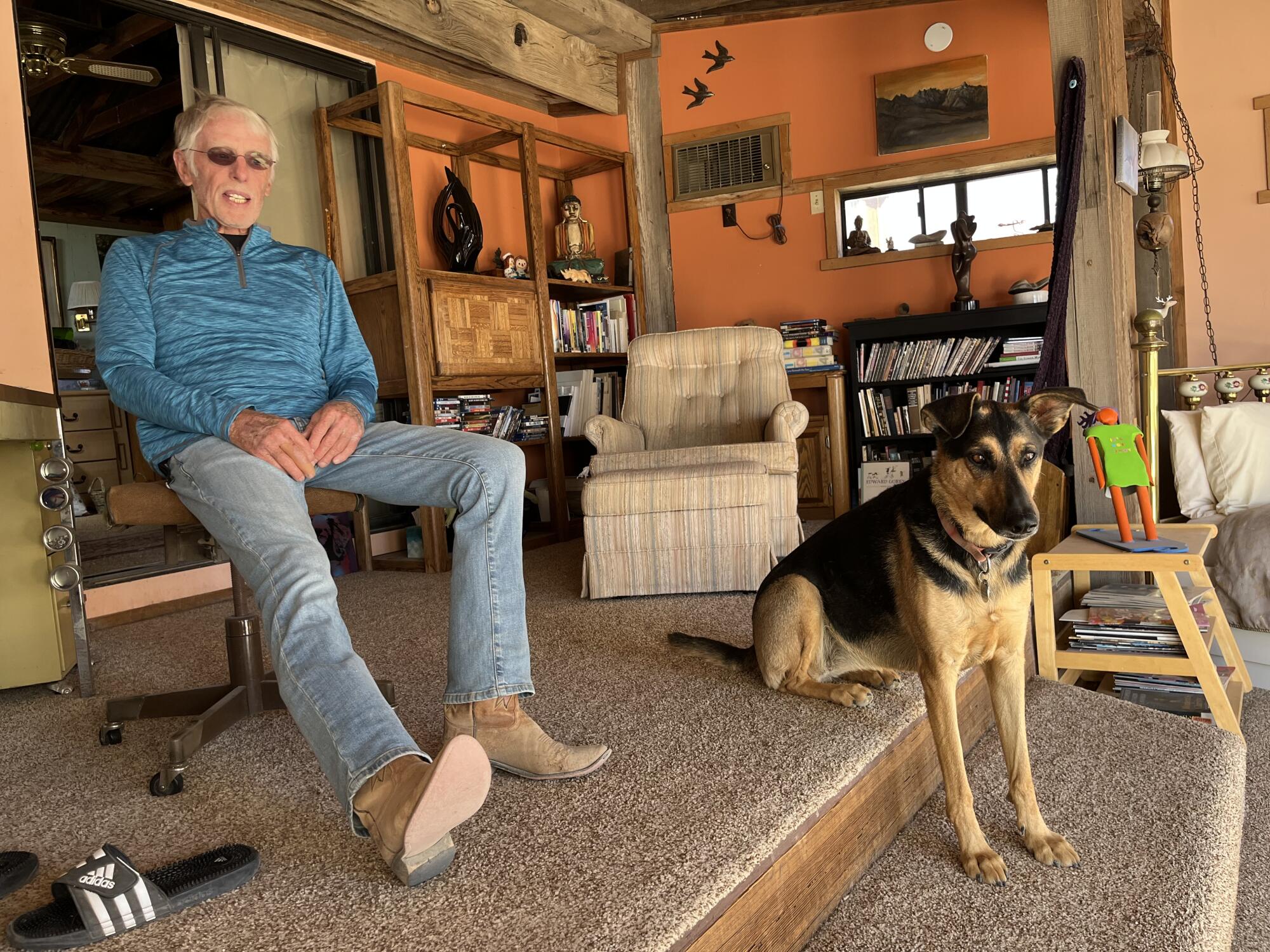 Darwin resident and sculptor Jim Hunolt sits in in home with his dog, Sabi.