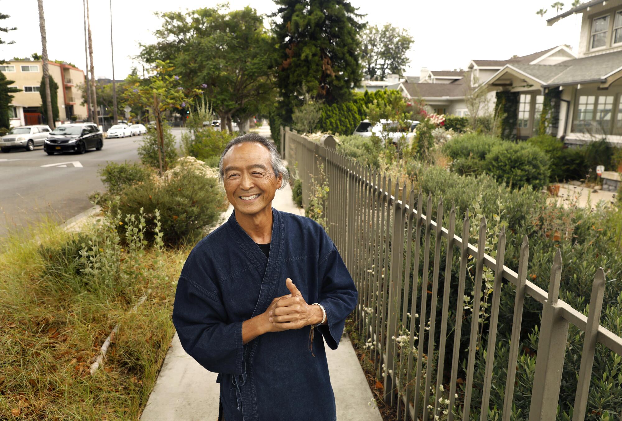 Georg Kochi stands on the sidewalk in front of his Koreatown Craftsman home. 