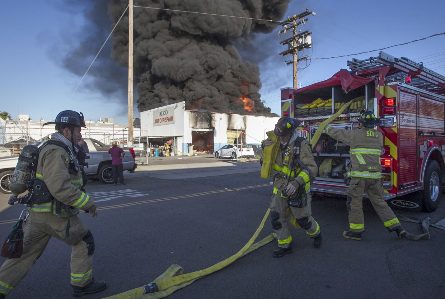 First arriving units connect to a hydrant across the street at a two-alarm fire that destroyed two businesses on Pacific Highway at Wright street Tuesday morning.