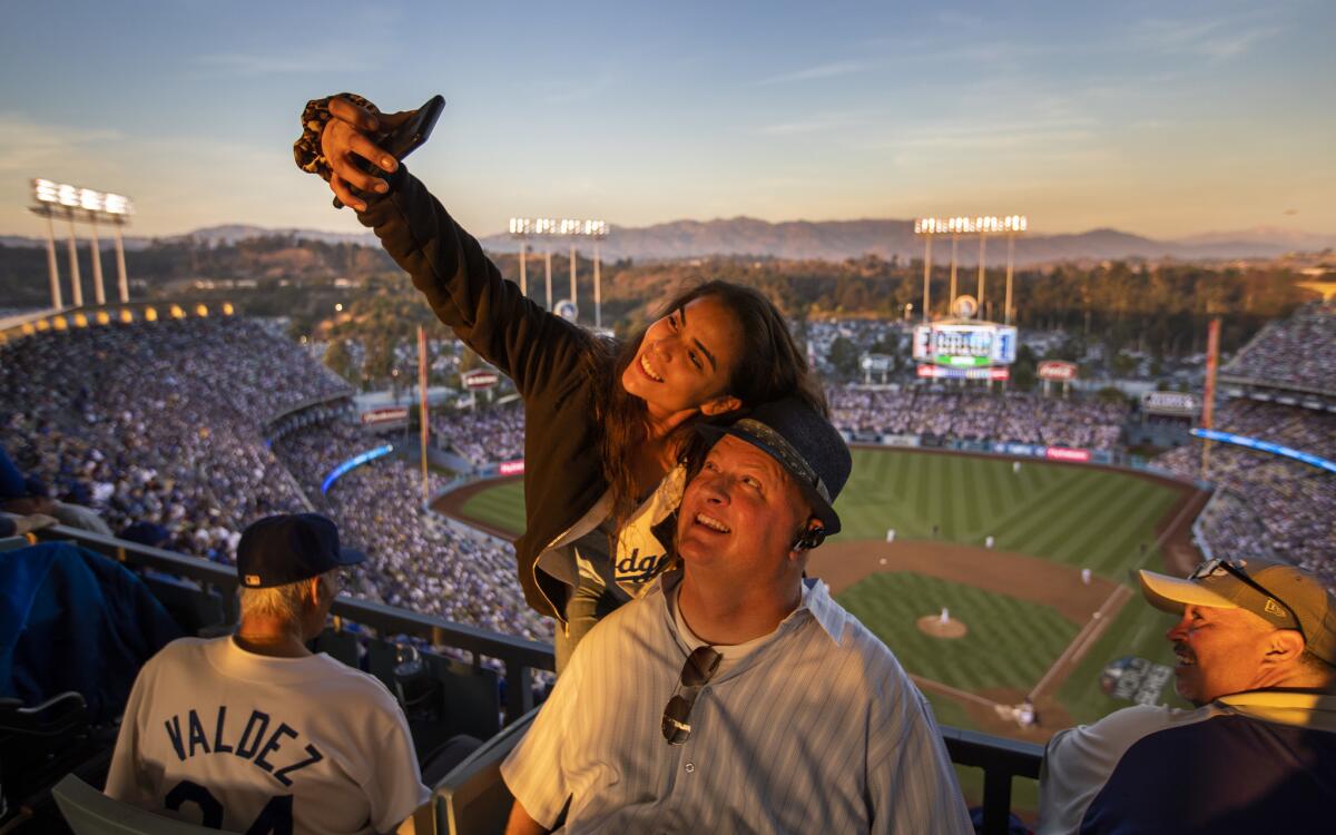 Dodgers fan Stephanie Ospina and Michael Warkentin, both of Long Beach, take a selfie as the sun sets during Game 3 of the World Series.