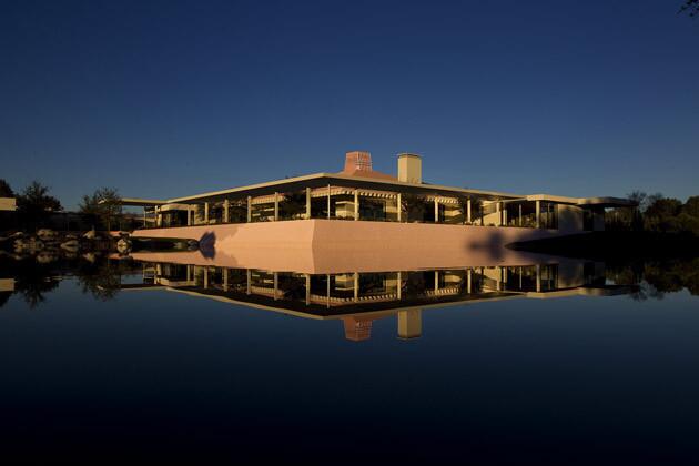 Leonore Annenberg favored pink, which accounts for the pink roof and walls. She admired how the color washed over the surrounding mountains at sunset. Here, the house and one of its pink garden retaining walls is mirrored in one of Sunnylands 11 artificial lakes.