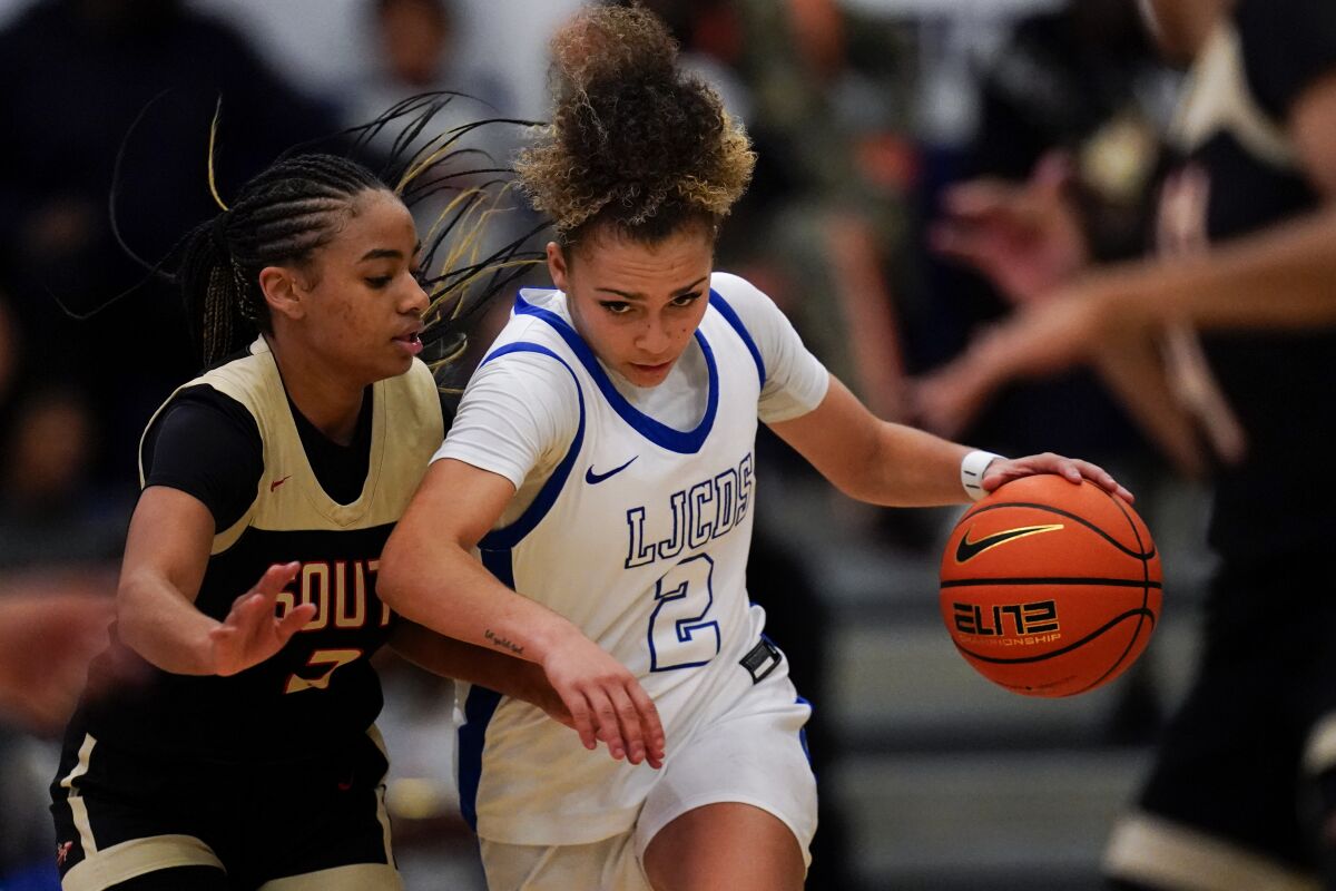 La Jolla Country Day point guard Jada Williams, center, drives to the basket during a Nov. 18 game.