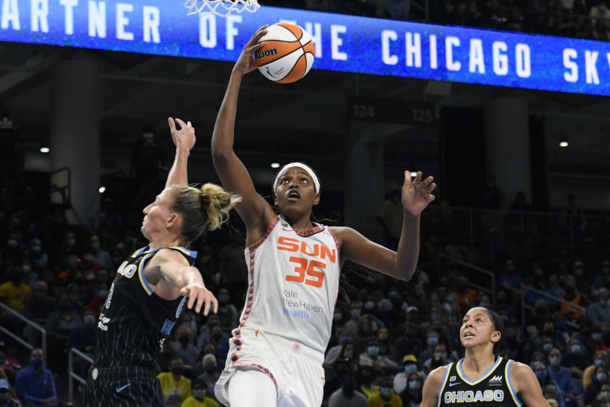 FILE - Connecticut Sun's Jonquel Jones (35) goes up for a shot against Chicago Sky's Courtney Vandersloot (22) and Candace Parker right, during the second half of Game 4 of a WNBA basketball playoff semifinal, Wednesday, Oct. 6, 2021, in Chicago. Jones says she's had a certain level of anonymity off of the basketball court, only occasionally being recognized outside the Mohegan Sun arena as one of the best players in the WNBA. But now, thanks in part to an MVP season and a popular insurance commercial, the 6-foot-6 forward from the Bahamas is being introduced to a much wider audience. (AP Photo/Paul Beaty, File)