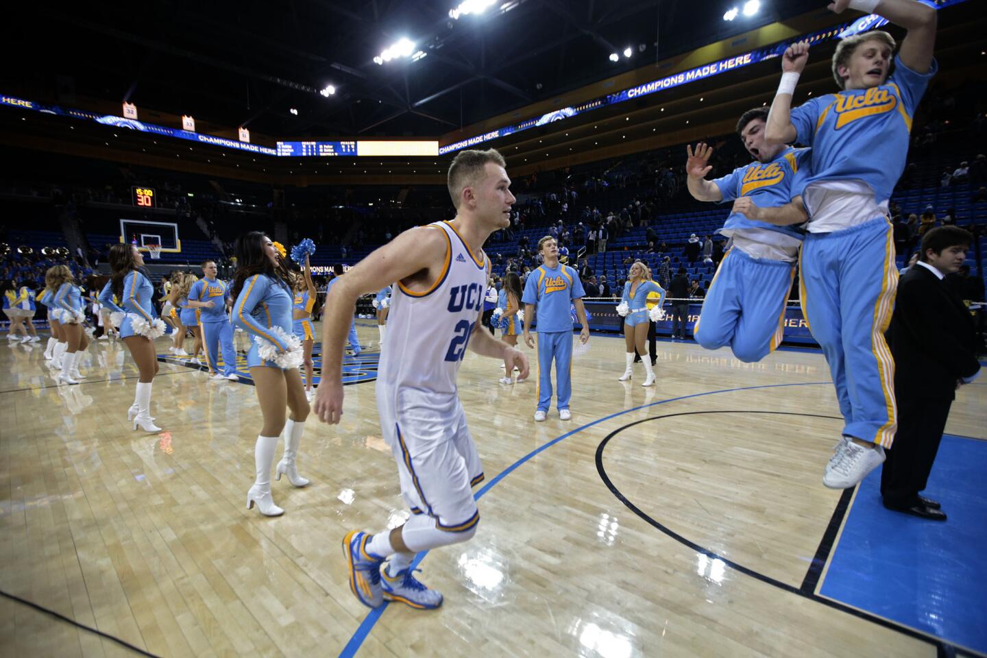 UCLA cheerleaders celebrate as guard Bryce Alford trots off the court after leading the Bruins to an 87-84 win over Arizona at Pauley Pavilion.