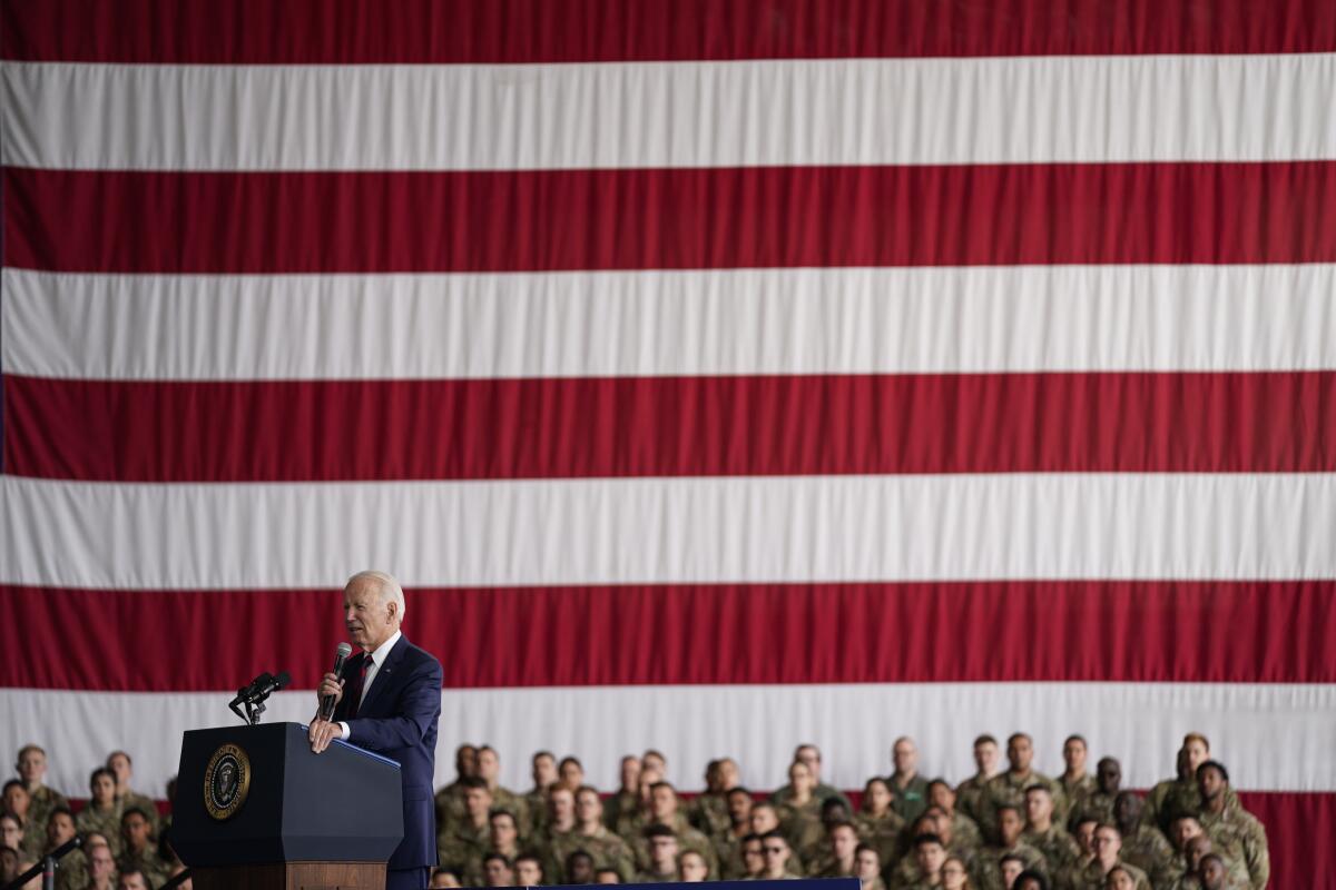 President Joe Biden speaks in front of an American flag.