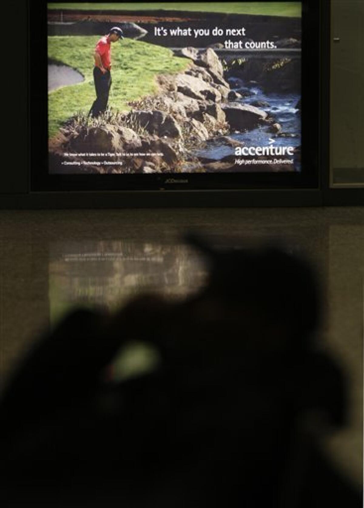 An ad for consulting firm Accenture featuring Tiger Woods is seen at Dulles International Airport in Chantilly, Va. Monday, Dec. 14, 2009. Accenture, which pinned its entire identity on the golfer, severed its ties with Woods on Sunday, days after he announced an indefinite leave from golf to work on his marriage after allegations of infidelity surfaced in recent weeks. (AP Photo/Luis M. Alvarez)