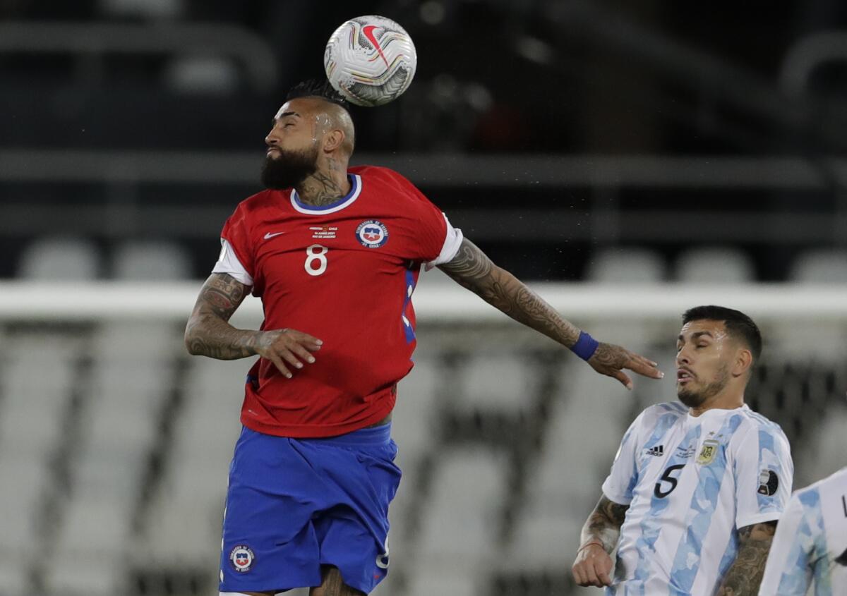 Arturo Vidal, de la selección de Chile, peina un balón frente a Leandro Paredes, de Argentina.