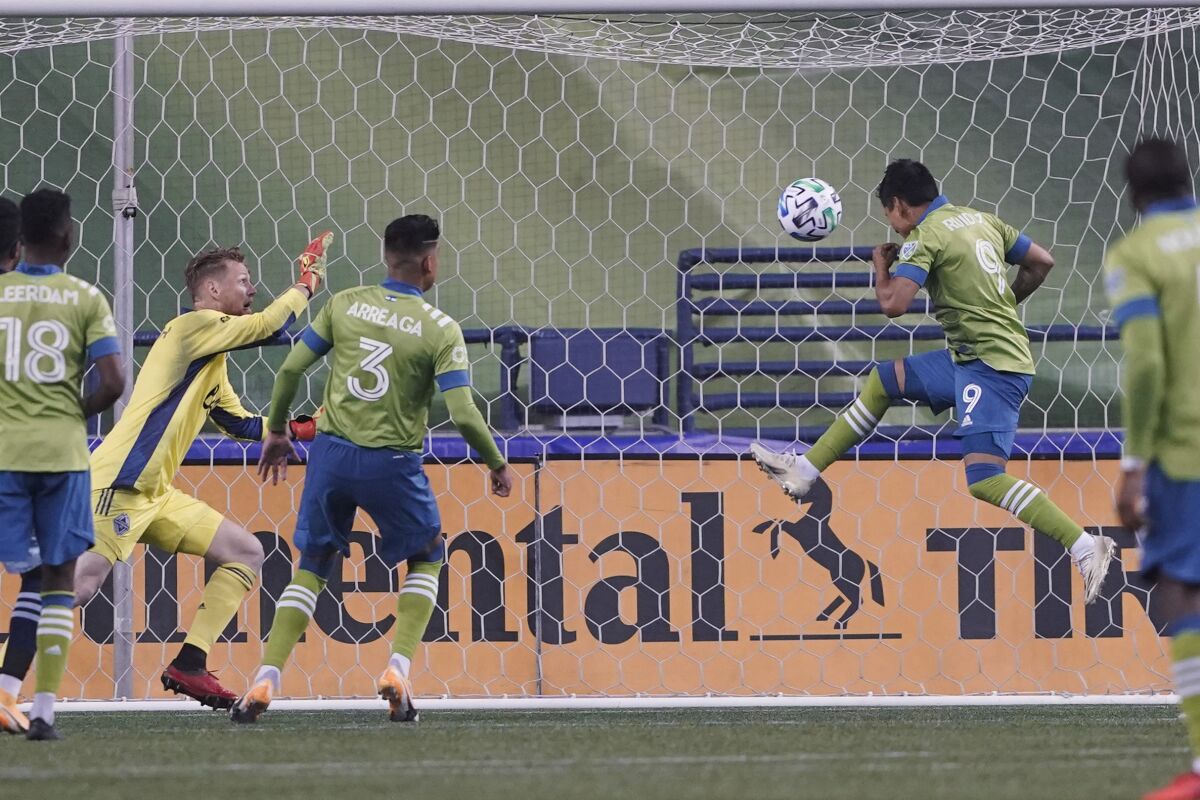 Seattle Sounders forward Raul Ruidiaz (9) scores a goal against Vancouver Whitecaps goalkeeper Bryan Meredith, second from left, during the second half of an MLS soccer match Saturday, Oct. 3, 2020, in Seattle. The Sounders won 3-1. (AP Photo/Ted S. Warren)