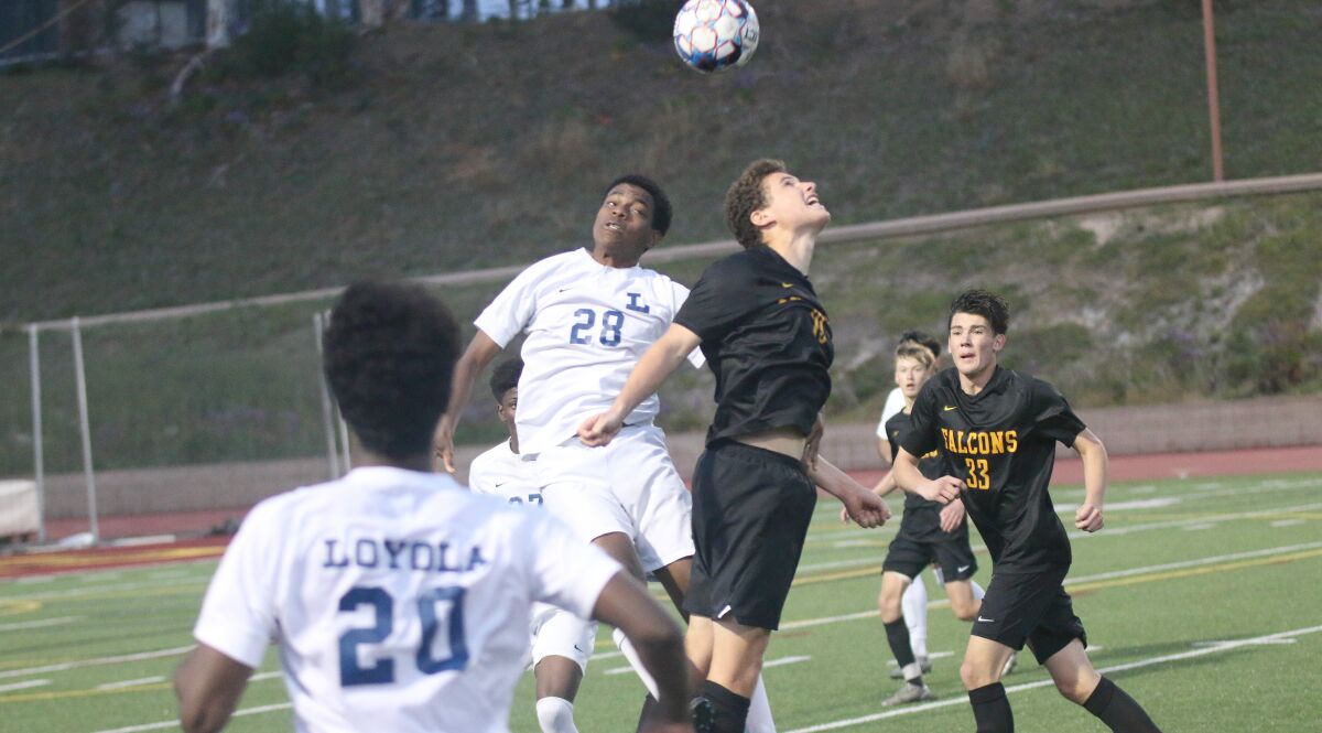 Falcon sophomore Charlie Kosakoff battles Loyola's David Merrille for possession.