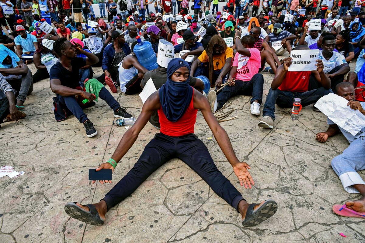 Los migrantes africanos participan en una protesta sentándose frente al centro de migrantes para exigir visas humanitarias que les permitirían cruzar México camino a EE.UU.