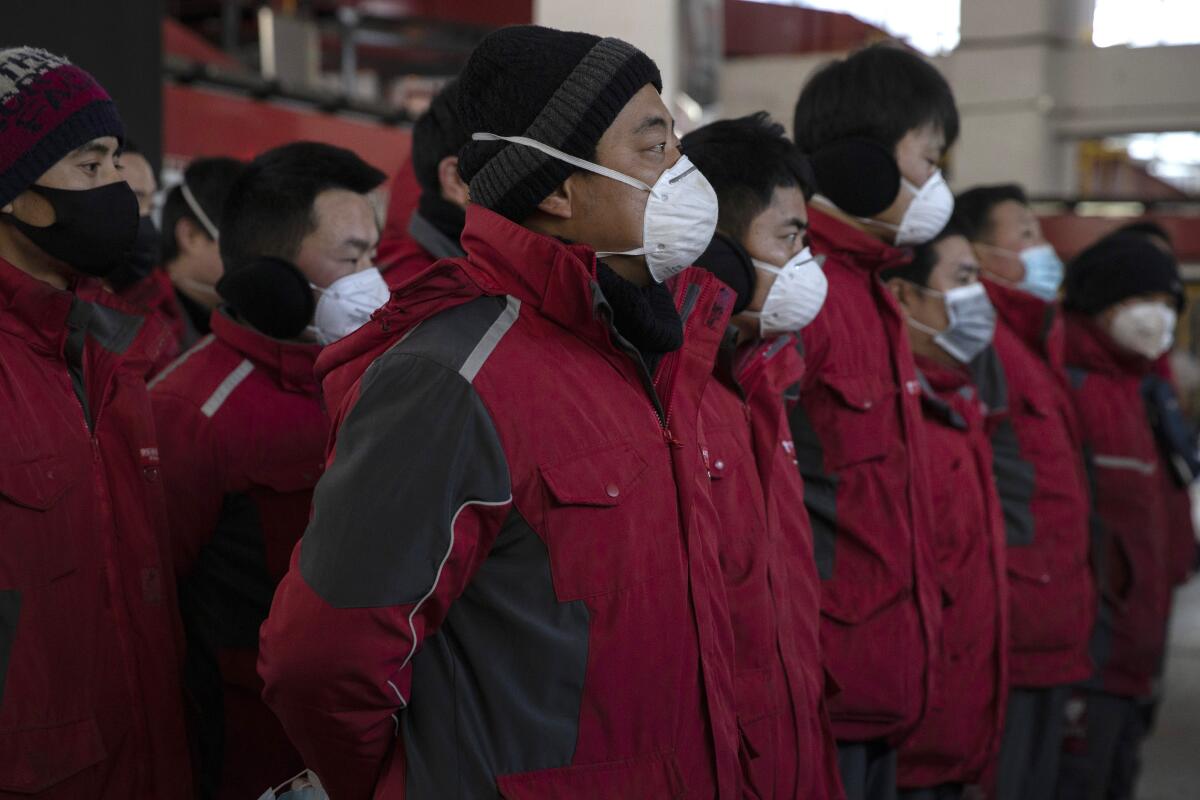 Drivers for Chinese e-commerce giant JD.com wear masks as they prepare for morning deliveries in Beijing on Tuesday.