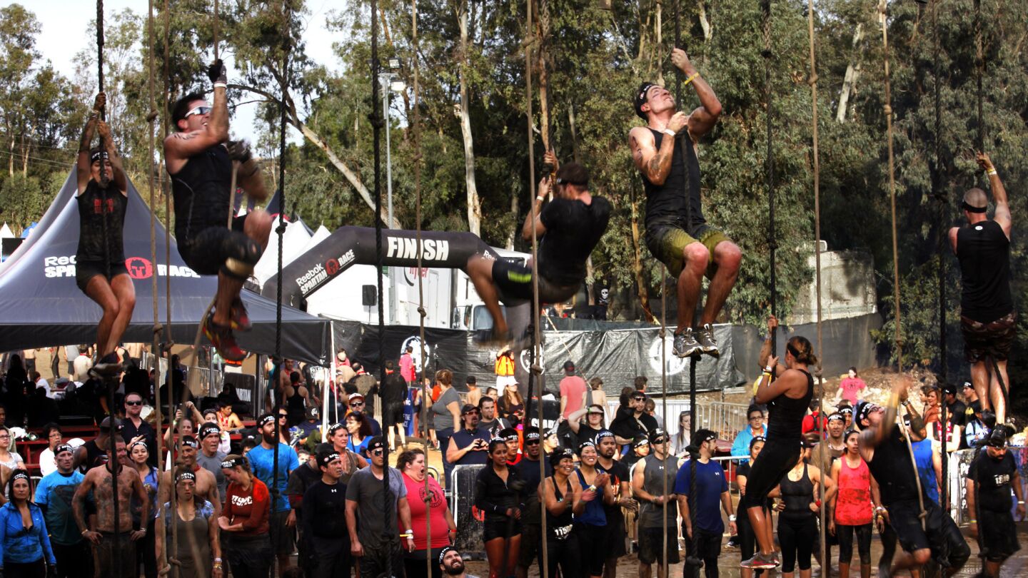 Participants take part in the rope climb challenge as others wait their turn during the Spartan Race at Calamigos Ranch in Malibu on Dec. 7, 2014. More than 5,200 people took part in the three-mile race which features several physically daunting challenges.