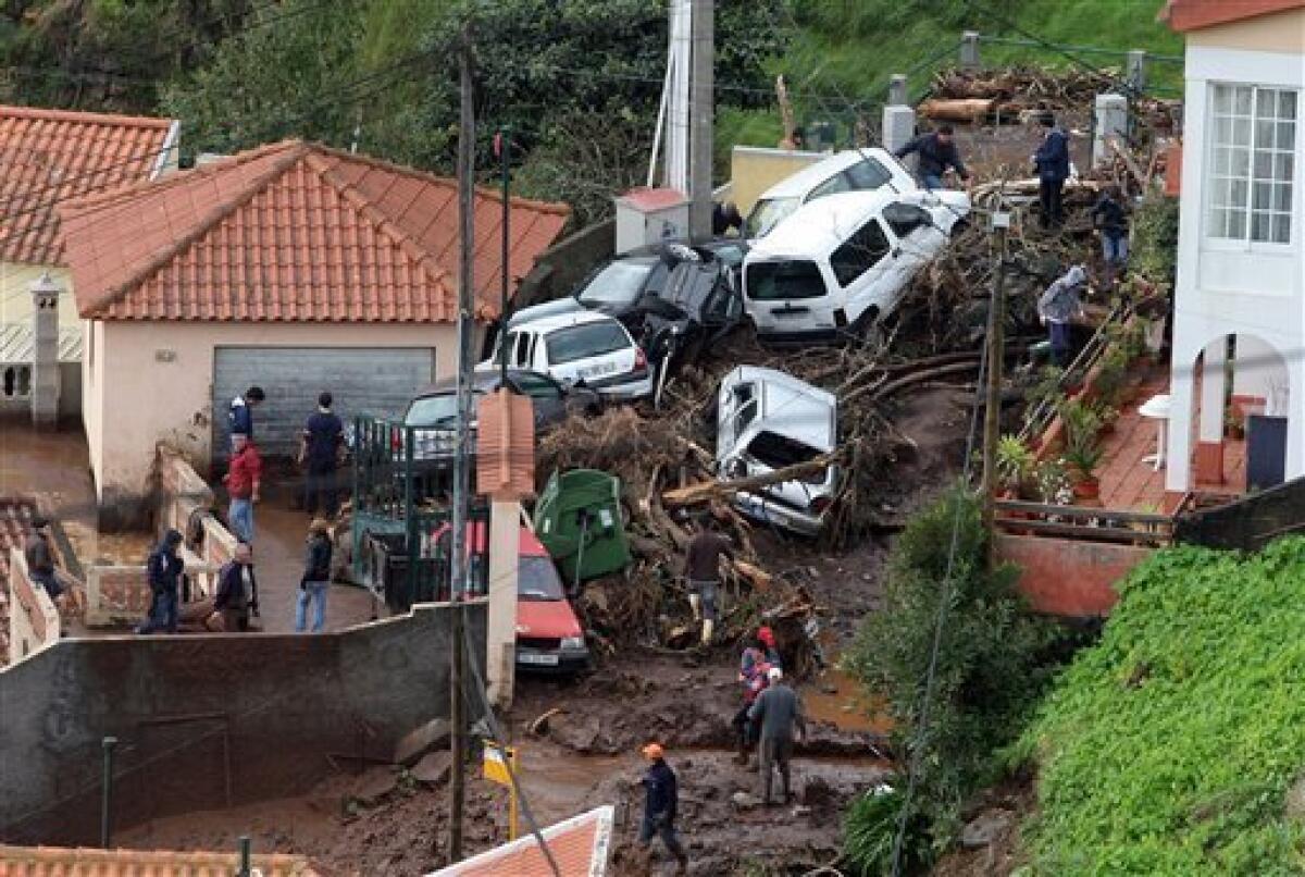 Cars are seen piled up among houses on a hillside outside Funchal, the Madeira Island's capital, Saturday, Feb. 20 2010. The cars were carried down the hill ogether with mud and debris as heavy rain caused flash floods all around the Portuguese island on Saturday. The local government has confirmed at least 40 dead. (AP Photo/Octavio Passos)