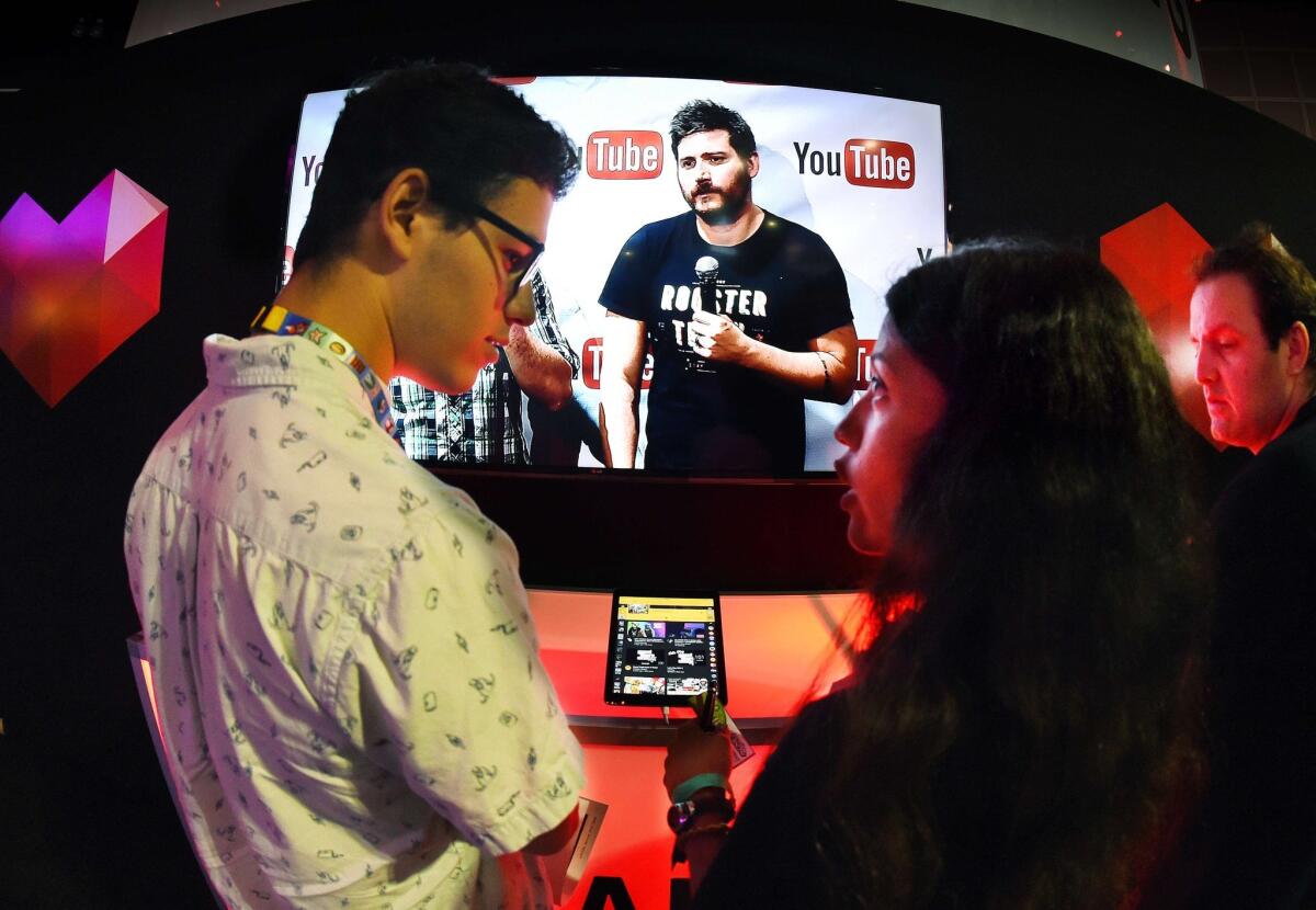 Visitors to the Electronic Entertainment Expo in downtown L.A.'s convention center on June 17 stand in front of a display promoting YouTube's venture into game streaming called "YouTube Gaming."