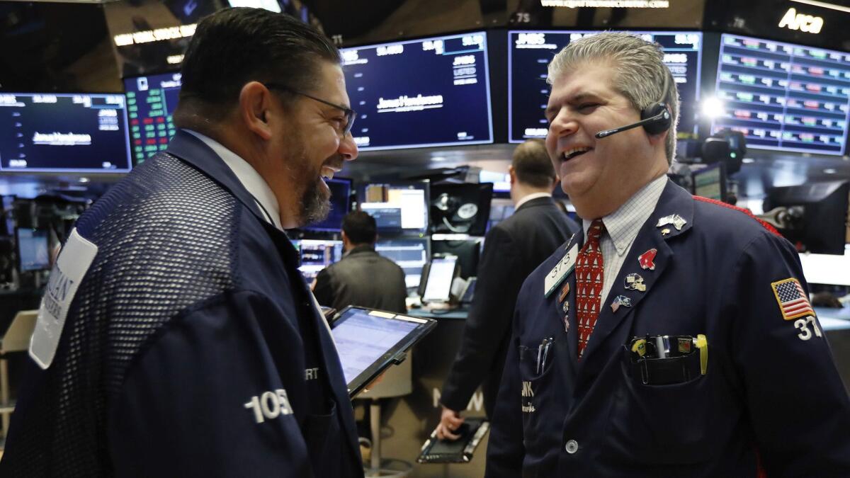 Traders Robert Oswald, left, and John Panin work Jan. 8 on the floor of the New York Stock Exchange.