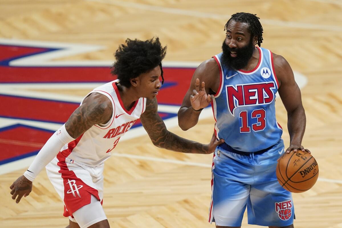 Brooklyn Nets' James Harden (13) calls out to a teammate as Houston Rockets' Kevin Porter Jr. (3) defends during the first half of an NBA basketball game Wednesday, March 31, 2021, in New York. (AP Photo/Frank Franklin II)