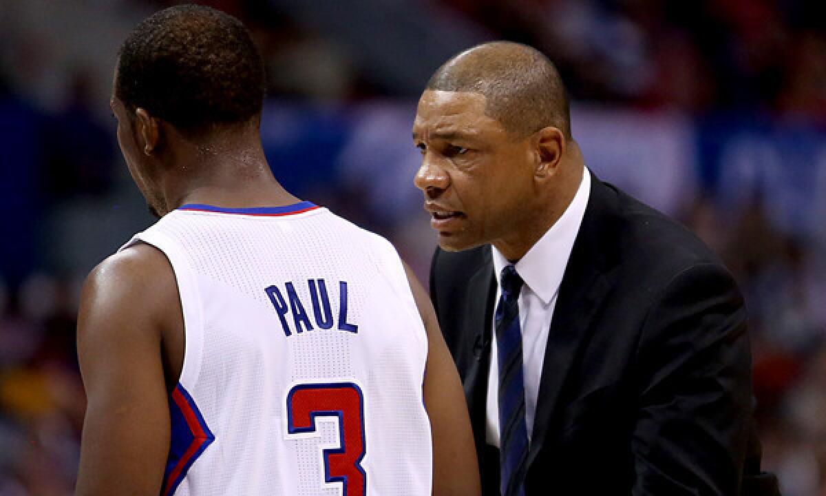 Clippers Coach Doc Rivers, right, speaks to point guard Chris Paul during a win over the Golden State Warriors on Oct. 31. Paul says he and Rivers share a desire to win.
