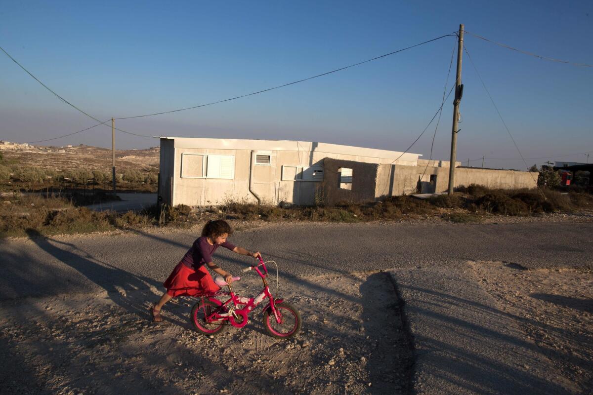 An Israeli girl walks with her bicycle near her home in the Amona settlement, northeast of the Palestinian city of Ramallah in the Israeli occupied West Bank on Sept. 7, 2016.