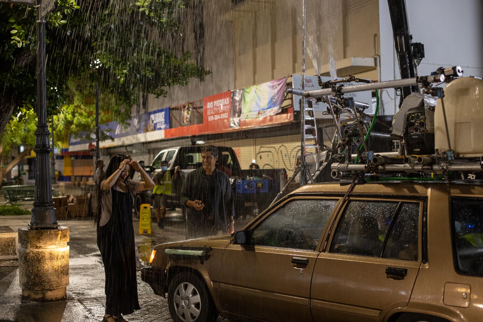 Kunjue Li and Esai Morales prepare to film a nighttime rain scene on the set of "Simone." 
