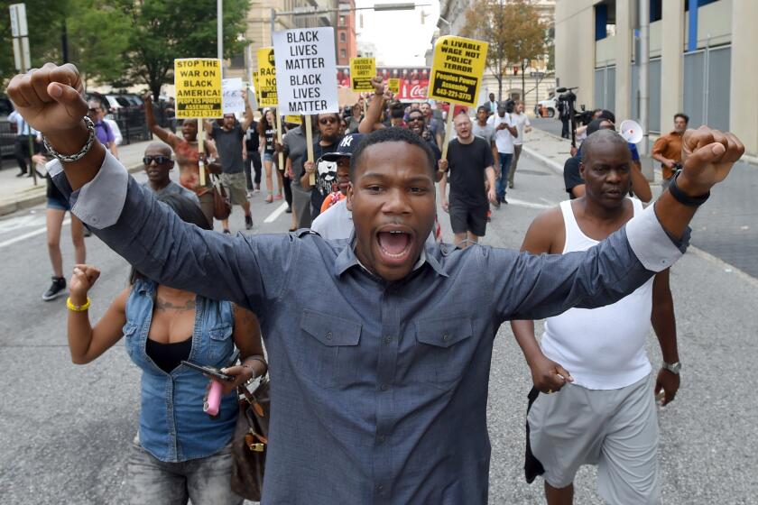 Pastor Westley West leads protesters down Guilford Avenue towards the Inner Harbor where one was arrested as the crowd blocked traffic on Pratt Street.