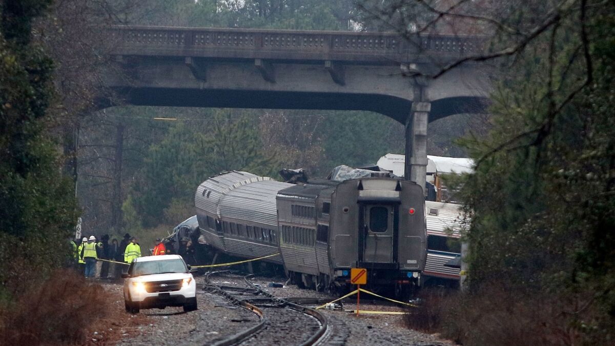 Investigators make their way around wreckage under a highway overpass where two trains collided near Cayce, S.C., on Feb. 4.