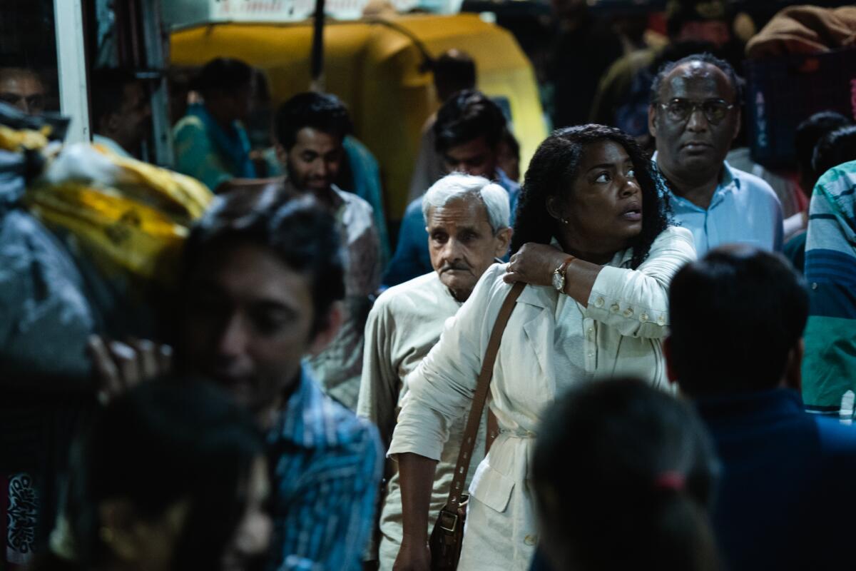 A woman looks around in a crowd of strangers.