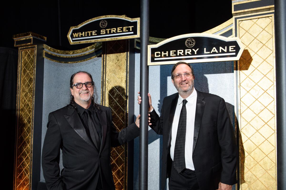 Glenn Weiss and Ricky Kirshner stand below street signs