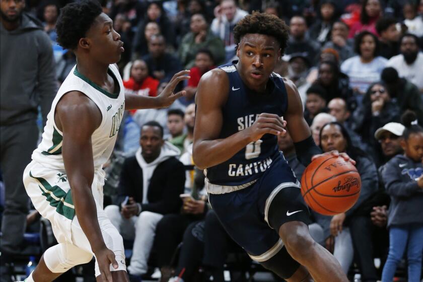 Sierra Canyon's Bronny James (0) drives against St. Vincent-St. Mary's Darrian Lewis during the second half of a high school showcase game on Dec. 14, 2019, in Columbus, Ohio.