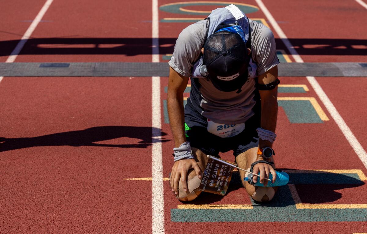 uki Naotori, 51, of Fukuoka Japan, kneels on the track at Placer High after crossing the finish line.
