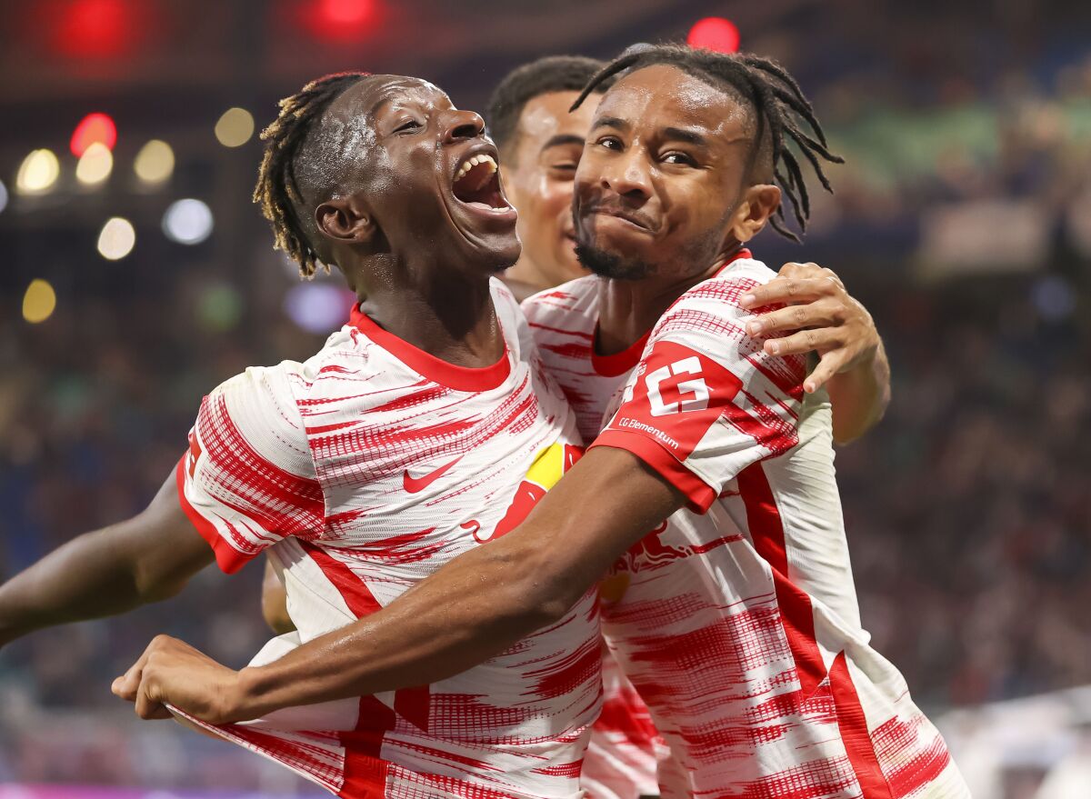 Leipzig's Christopher Nkunku, right, celebrates scoring with teammates Amadou Haidara, left, and Tyler Adams during the German Bundseliga soccer match between Leipzig and Vfl Bochum, at the Red Bull Arena in Leipzig, Germany, Saturday, Oct. 2, 2021. (Jan Woitas/dpa via AP)