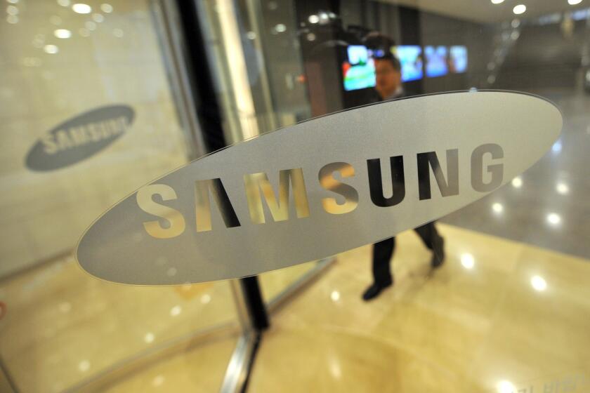 The Samsung logo is displayed on a glass door at its headquarters in Seoul.