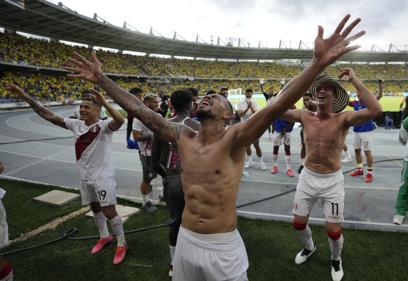 Peruvian players celebrate at the end of the game against Colombia