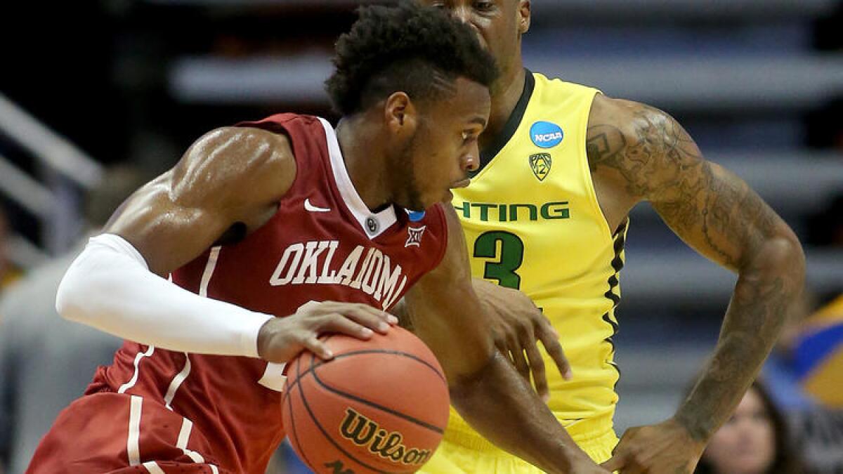 Oklahoma guard Buddy Hield drives to the basket againt Oregon forward Elgin Cook during the second half of the West Regional Final on March 26 at Honda Center.