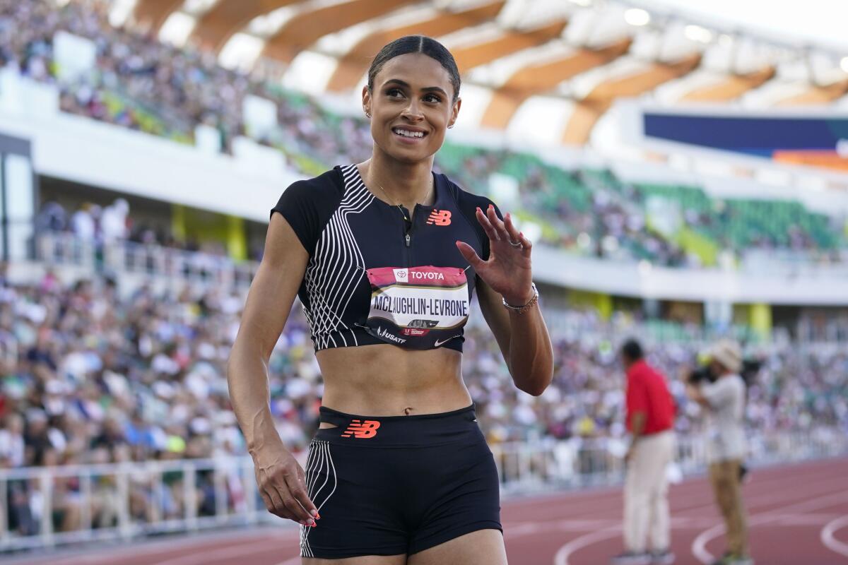 Sydney McLaughlin-Levrone waves to the crowd from a track.