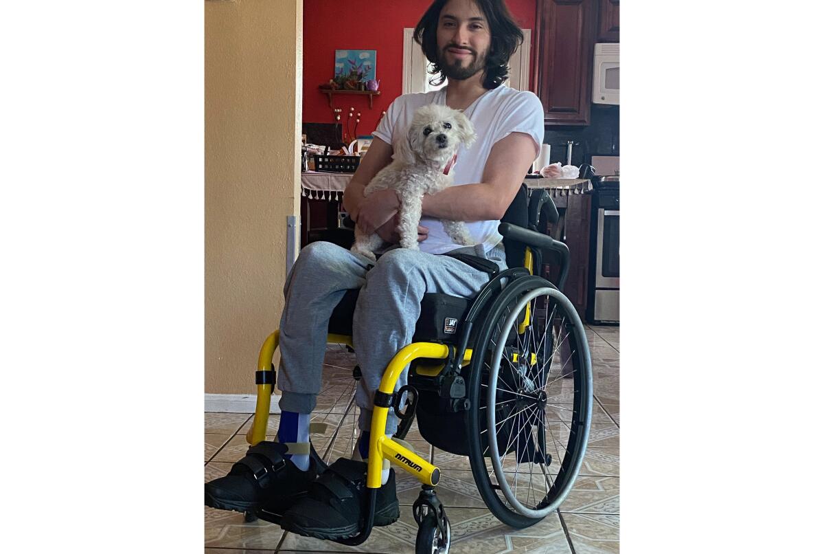 Isaias Cervantes in a wheelchair, with a dog on his lap