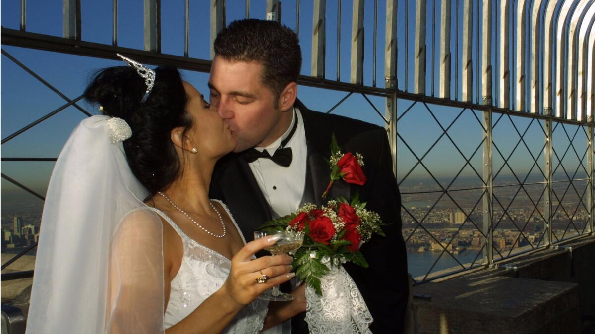 Newlyweds Caroline and Rob Driscoll, from Danbury, Conn., kiss after tying the knot in Valentine's Day marriage ceremonies on Feb. 14, 2002, atop New York's Empire State Building.